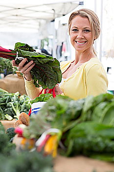 Image, Stock Photo Young woman shopping for fresh tomatoes at an open-air stall choosing items from a row of wooden boxes