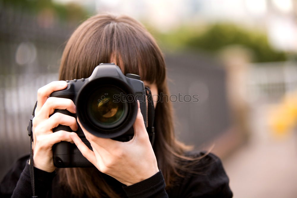 Similar – Smiling young woman using a camera to take photo at the park.