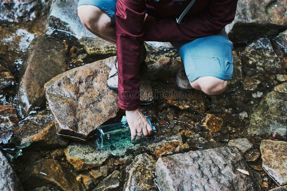 Similar – Boy sitting on a rock on mountain trail