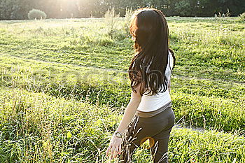 Similar – Winter ideas. Beautiful young girl stretching her finger upwards while snowing on a green meadow.