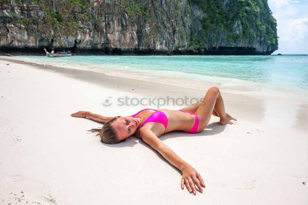 Similar – Beautiful girl lying at the beach in her swimsuit and reading a book