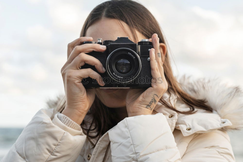 Similar – Smiling young woman using a camera to take photo at the park.