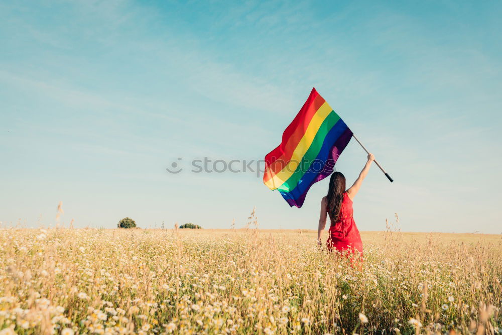 Similar – Image, Stock Photo Young woman holding a rainbow flag behind a fence