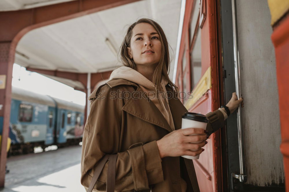 Similar – Fröhliches Mädchen steigt am Bahnhof mit Kaffee in der Hand in den Zug ein.