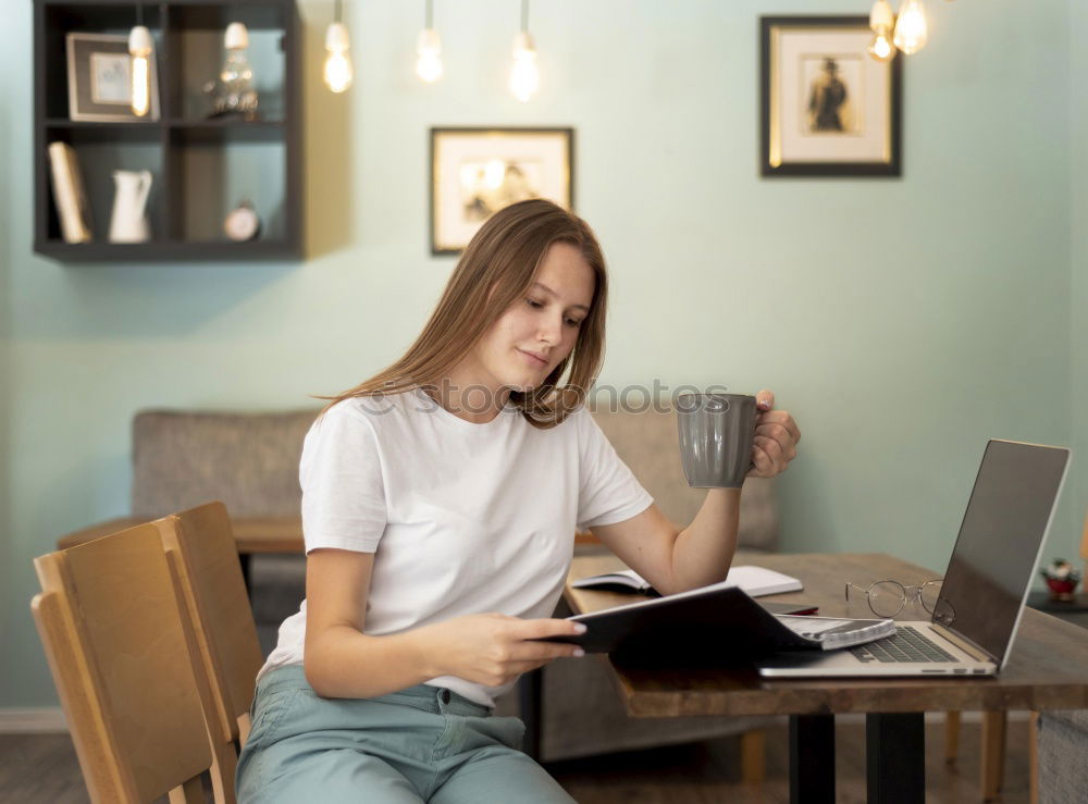 Similar – Young businesswoman working on laptop and drinking coffee