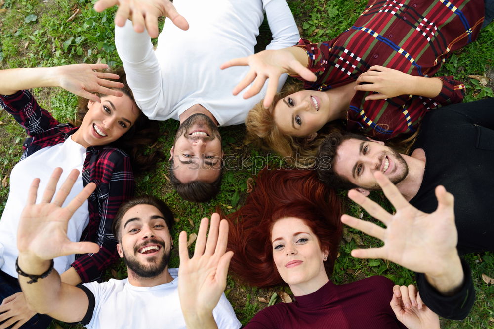 Similar – Women and men laying on grass wearing casual clothes.