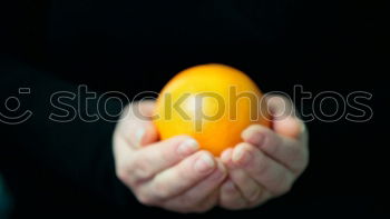 Similar – hand holding an orange in original shape