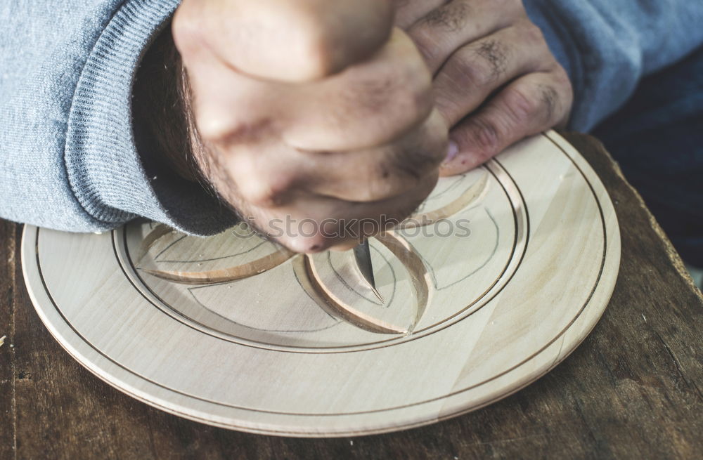 Similar – Hands of woodcarver make wooden bowl