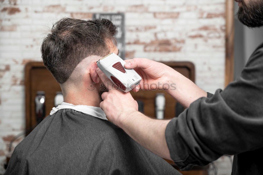 Similar – Foto Bild Detail der Hände eines Friseurs, der einem Kunden mit einem Rasiermesser die Haare schneidet