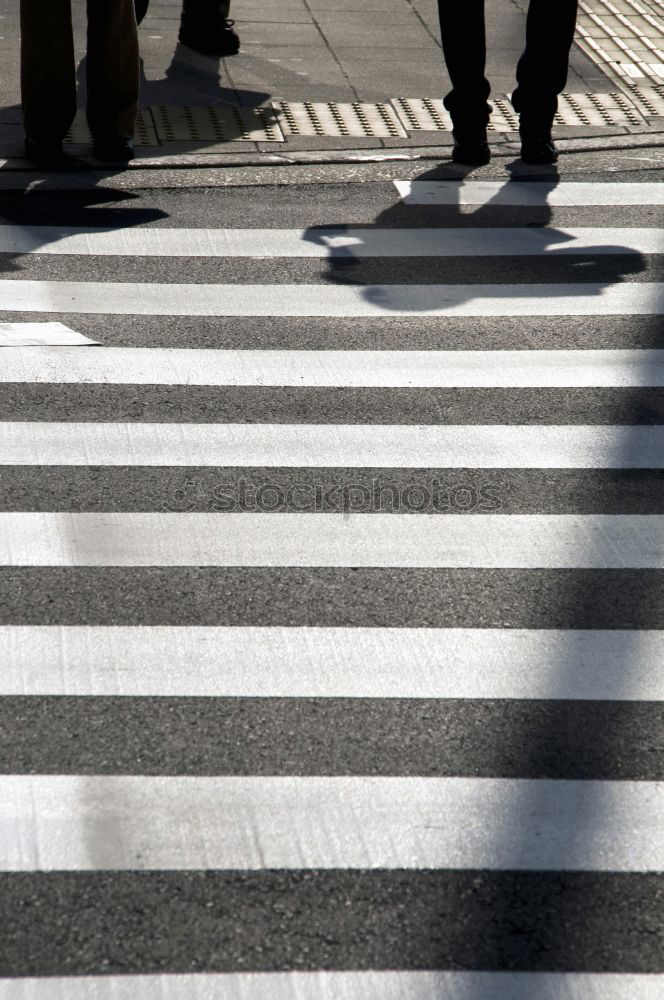 Similar – Silhouette of a woman standing on one leg on a large paved square in backlight with shadow