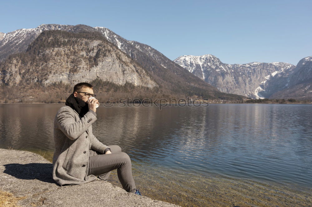 Similar – Woman sitting on stone at lake