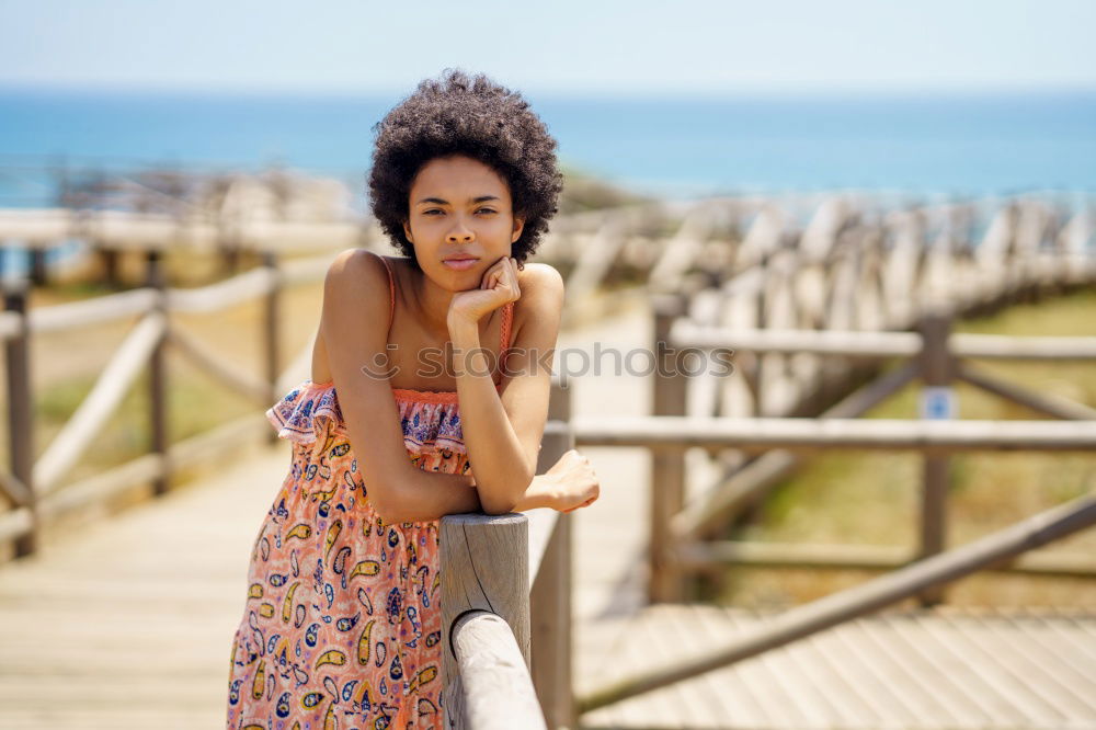 Similar – Woman with afro hairstyle sitting on a bench moving her legs