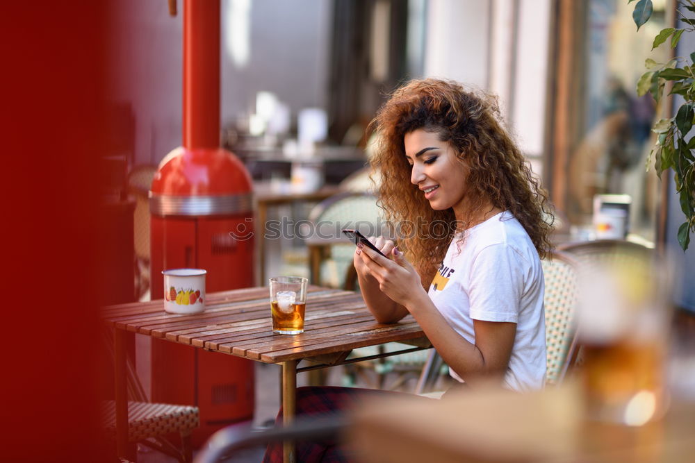 Similar – Image, Stock Photo Girl sitting in a street bar looking at her smartphone