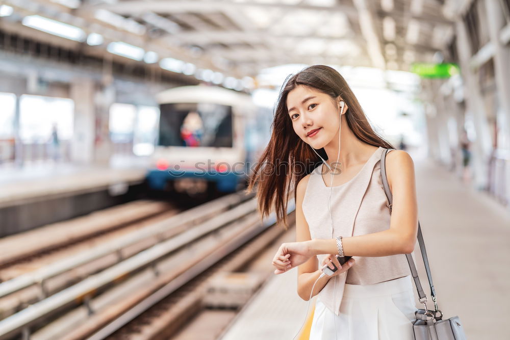 Fröhliches Mädchen steigt am Bahnhof mit Kaffee in der Hand in den Zug ein.