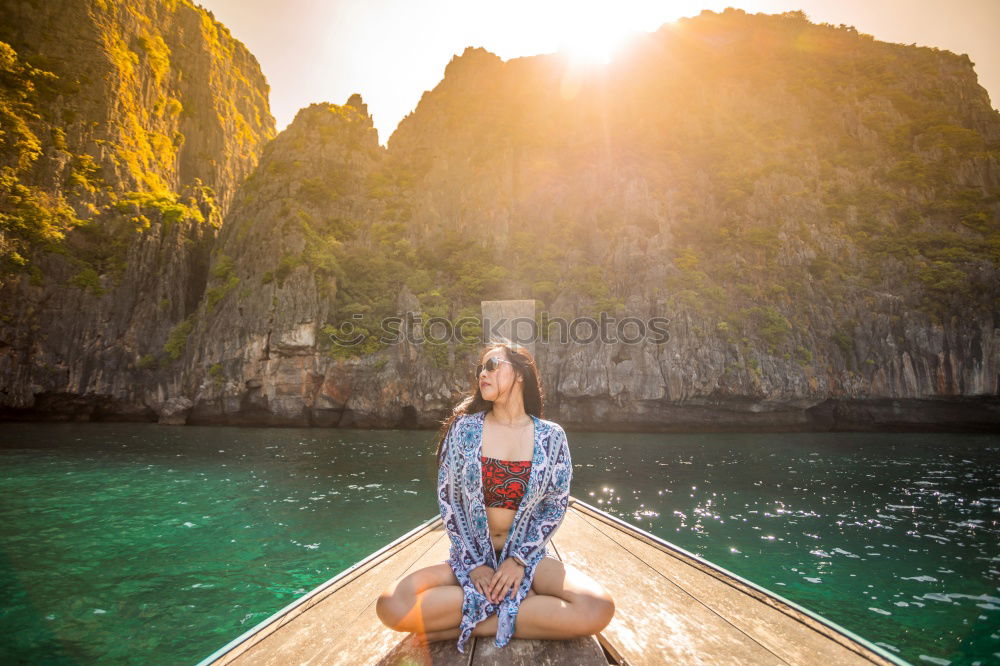 Similar – Woman sitting on stone at lake