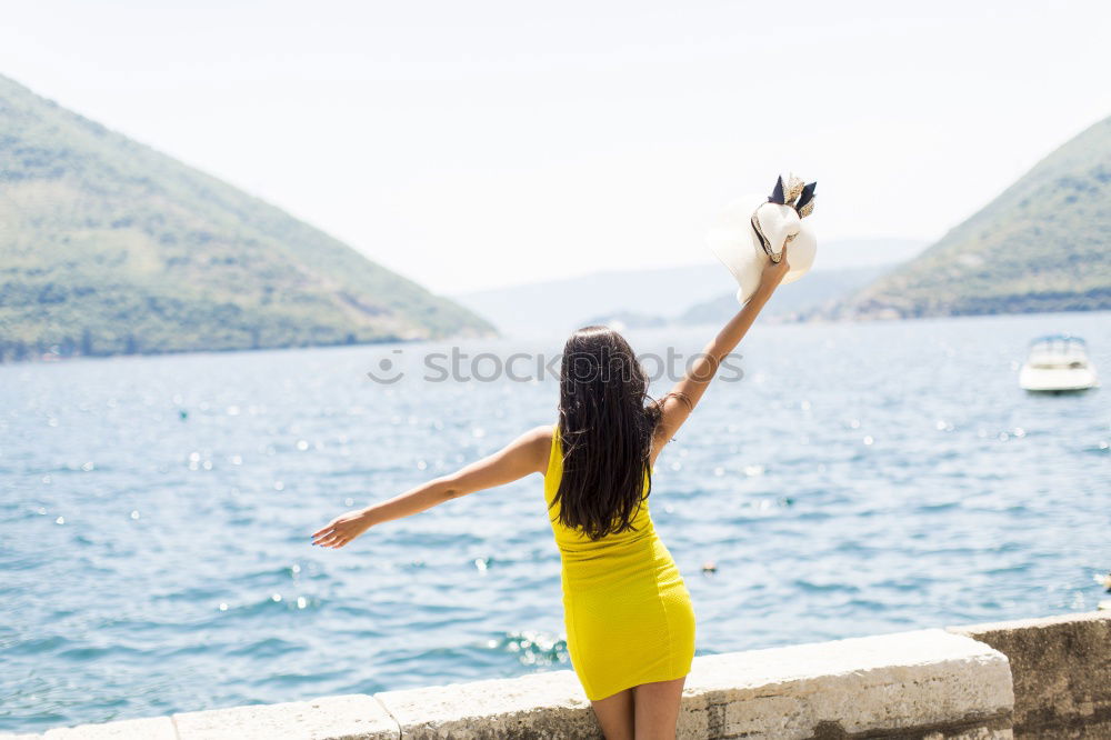 Similar – Woman sitting on stone at lake