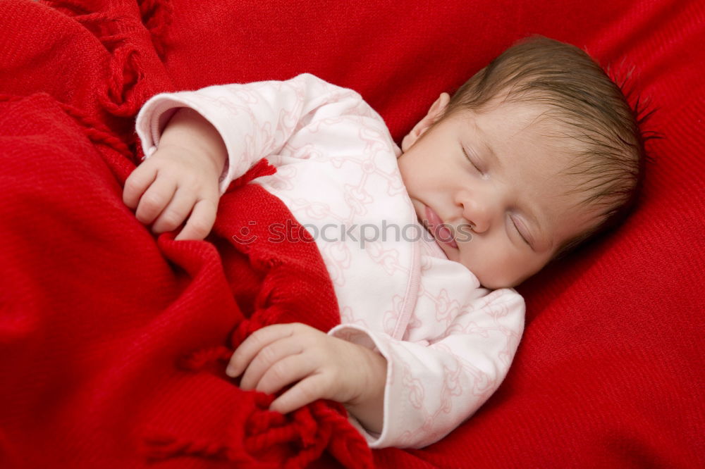 Similar – Adorable baby sleeping wrapped in a red blanket