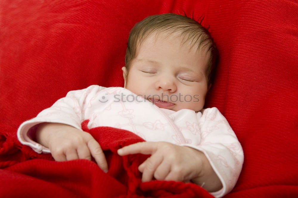 Similar – Adorable baby sleeping wrapped in a red blanket