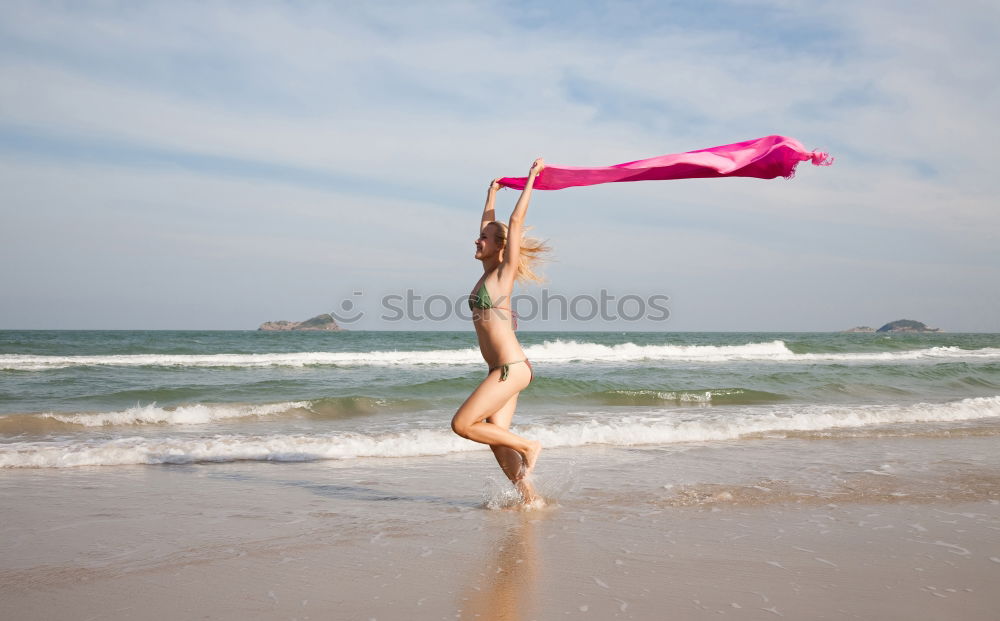 Anmutiger Akrobat mit Reifen am Strand