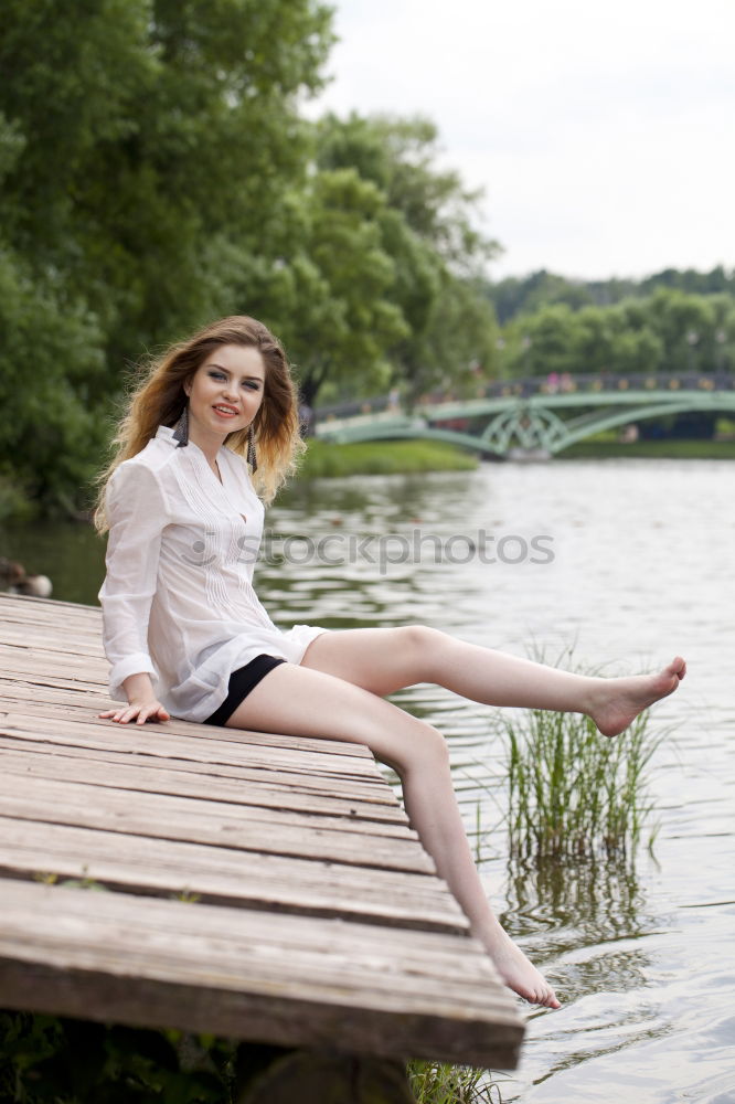 Similar – Young woman sitting on the banks of the Rhine with her feet in the water