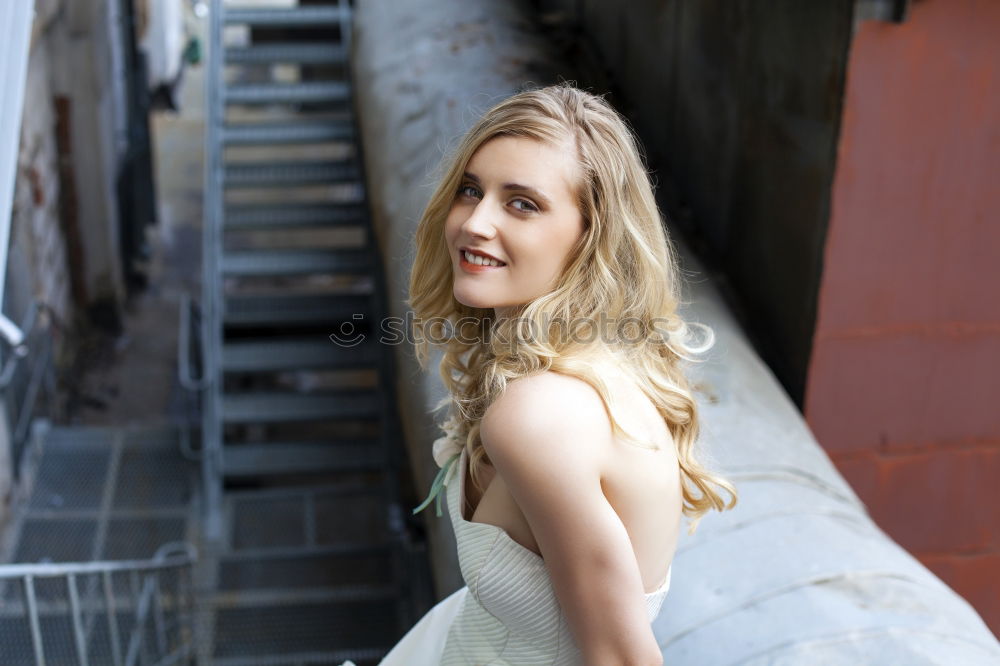 Similar – Image, Stock Photo Smiling woman in yellow dress standing and chatting on her smart phone in front of graffiti painted on corrugated iron