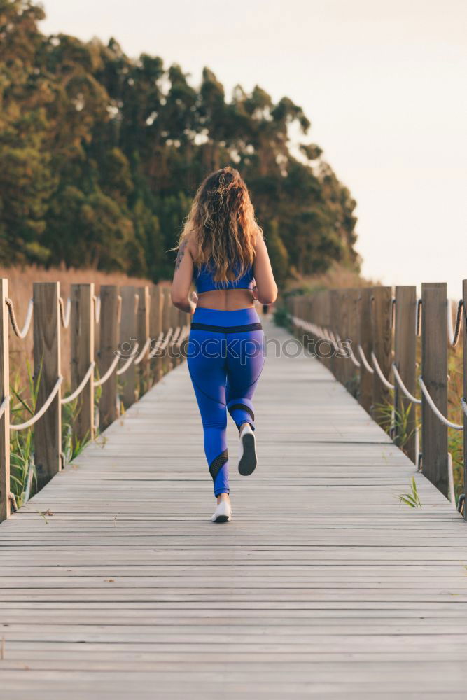 Similar – Young fitness woman runner running on city bridge.