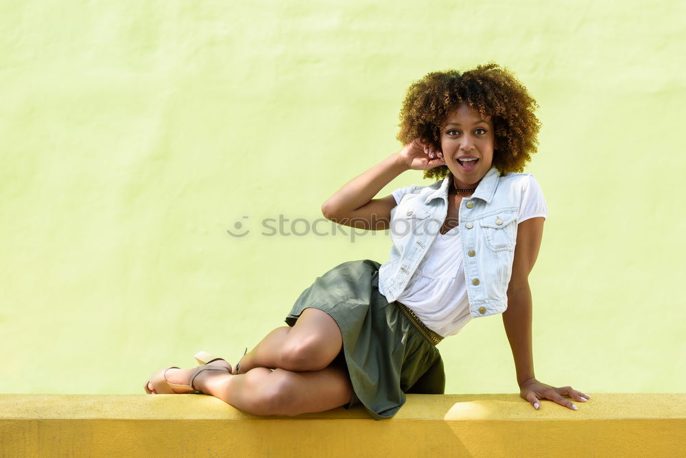 Young black woman, afro hairstyle, sitting outdoors