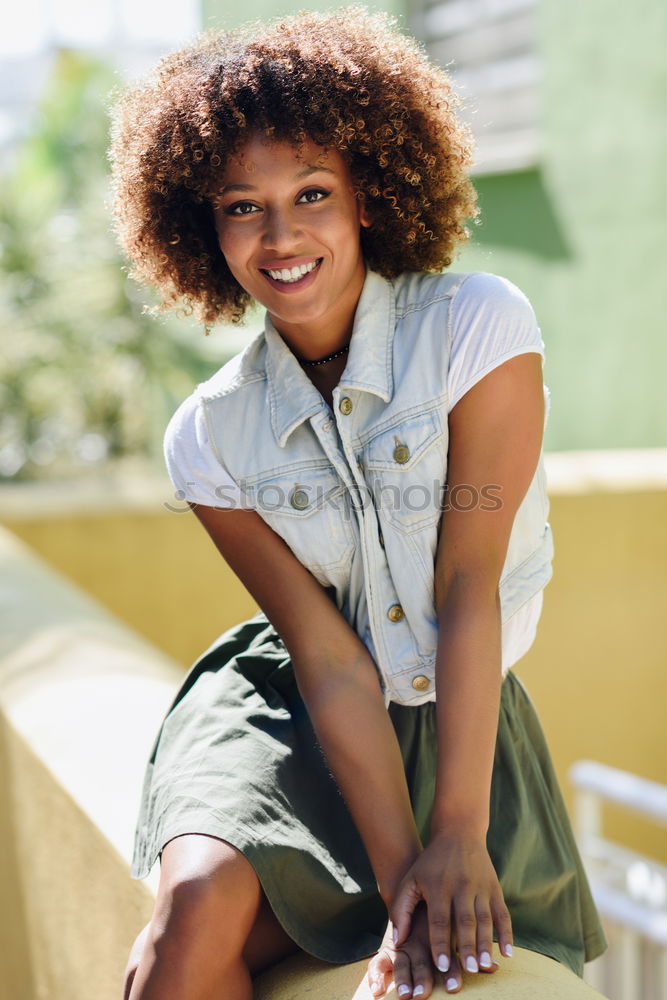 Young black woman, afro hairstyle, smiling.