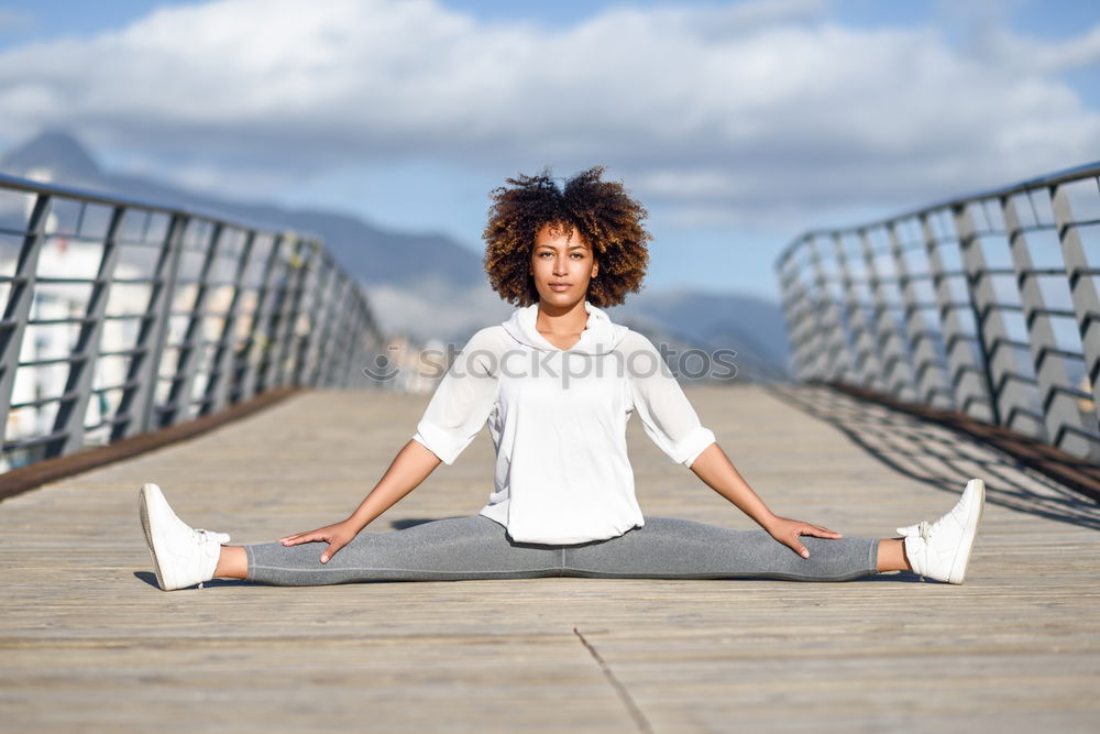 Similar – African American sportive woman sitting in lotus pose and stretching hands up