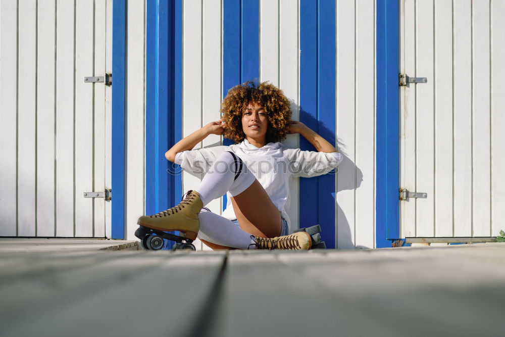 Similar – Woman with afro hairstyle sitting on a bench moving her legs