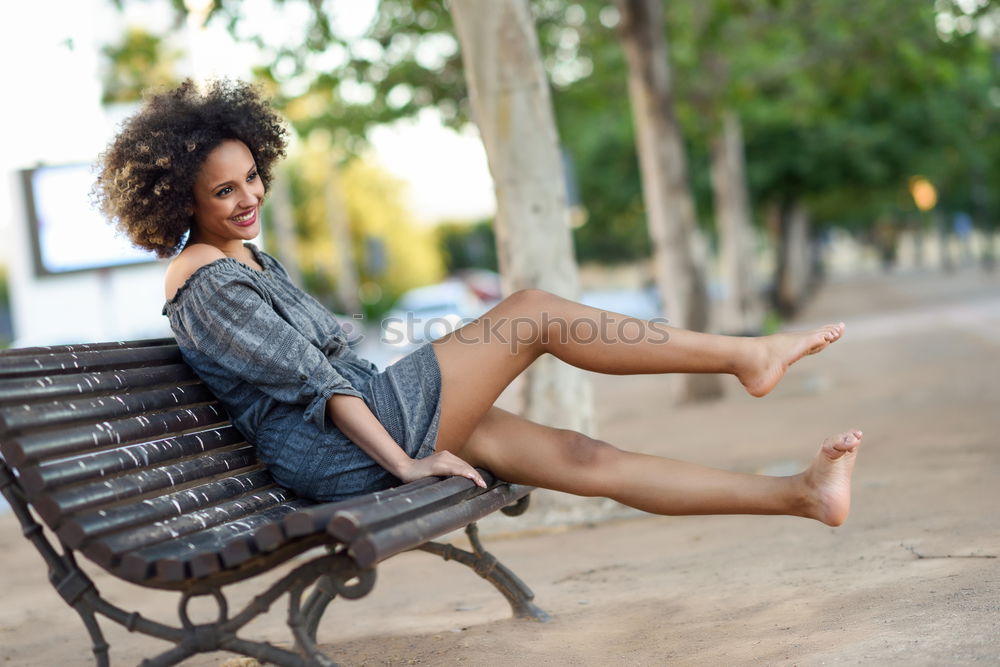 Young black woman with afro hairstyle sitting on a bench