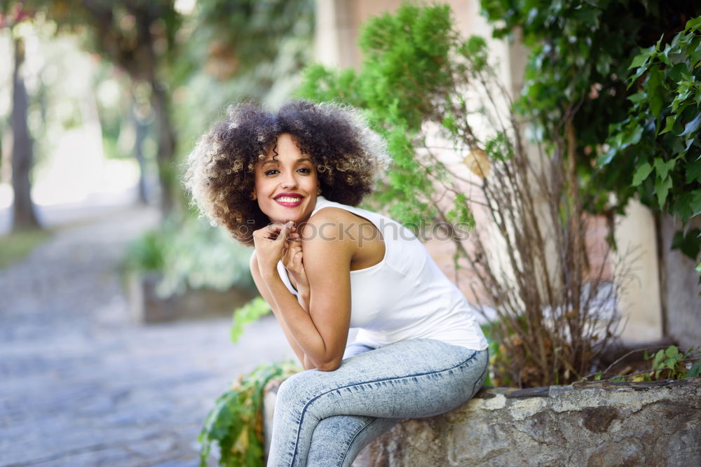 Young black woman with afro hairstyle smiling in urban park