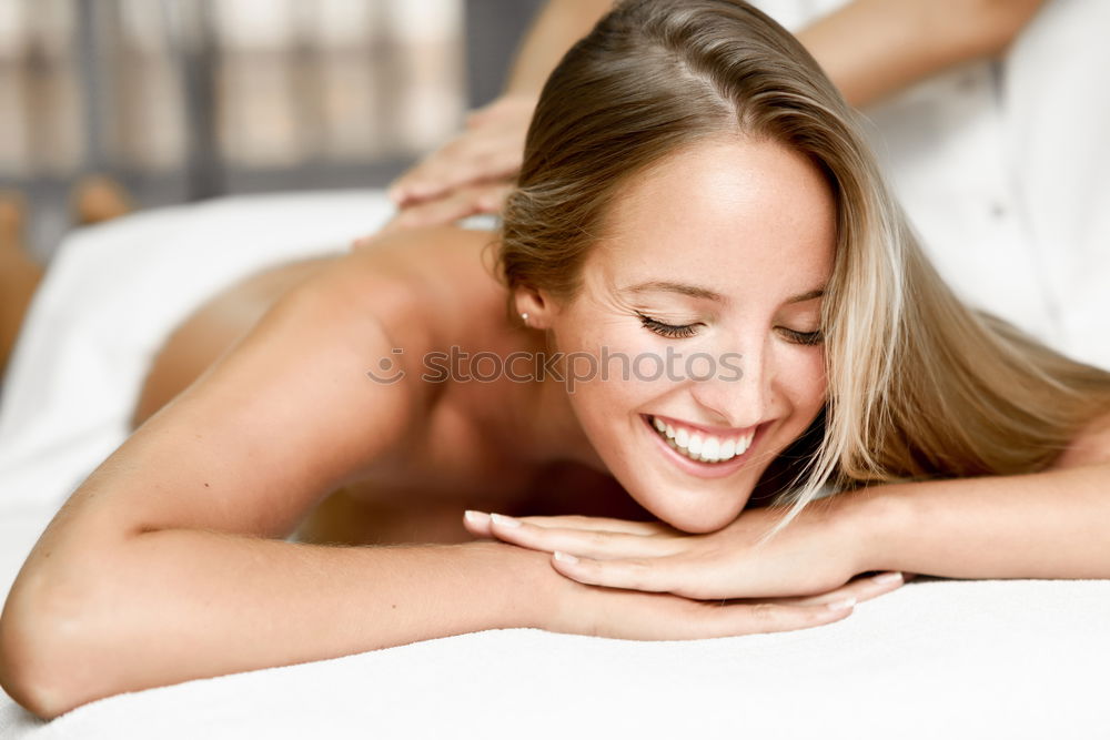 Young blond woman having massage in the spa salon.