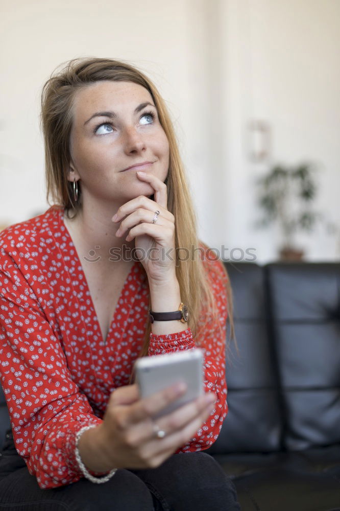 Image, Stock Photo Blonde girl using a smartphone while sitting on leather sofa