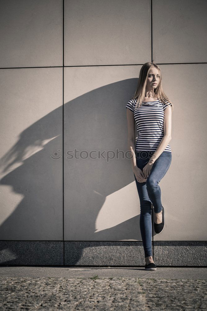 Woman in Winter Outfit in Front Old Gray Wall