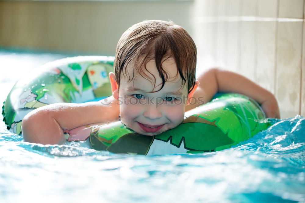 Image, Stock Photo Young boy in inflatable tube swimming with a big smile on his face