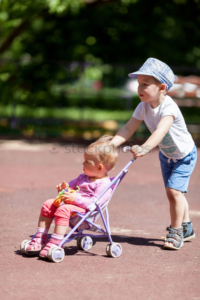 Image, Stock Photo Young boy pushing little sister in a baby stroller