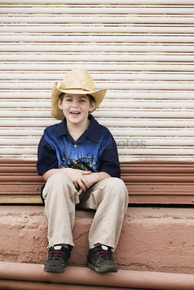 Similar – Little boy with a mibile phone with a wooden door background