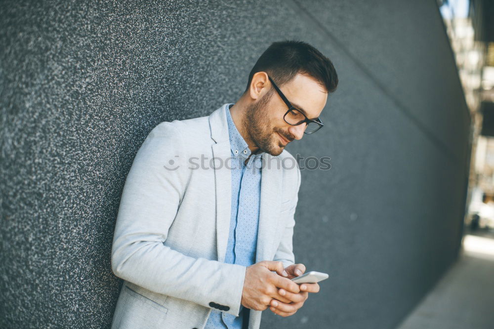 Similar – Image, Stock Photo Young smiling man looking at his smartphone in the street