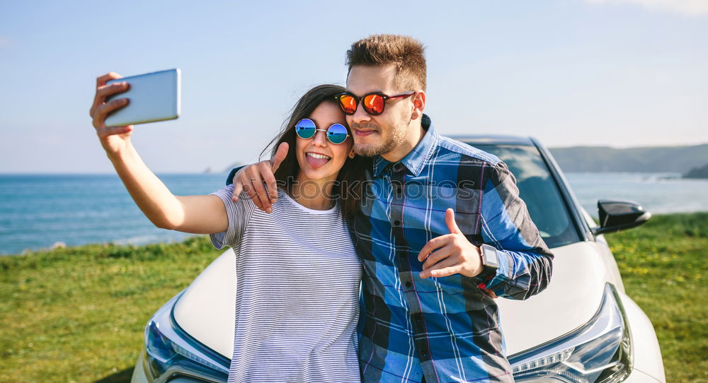 Young couple doing a selfie on the car