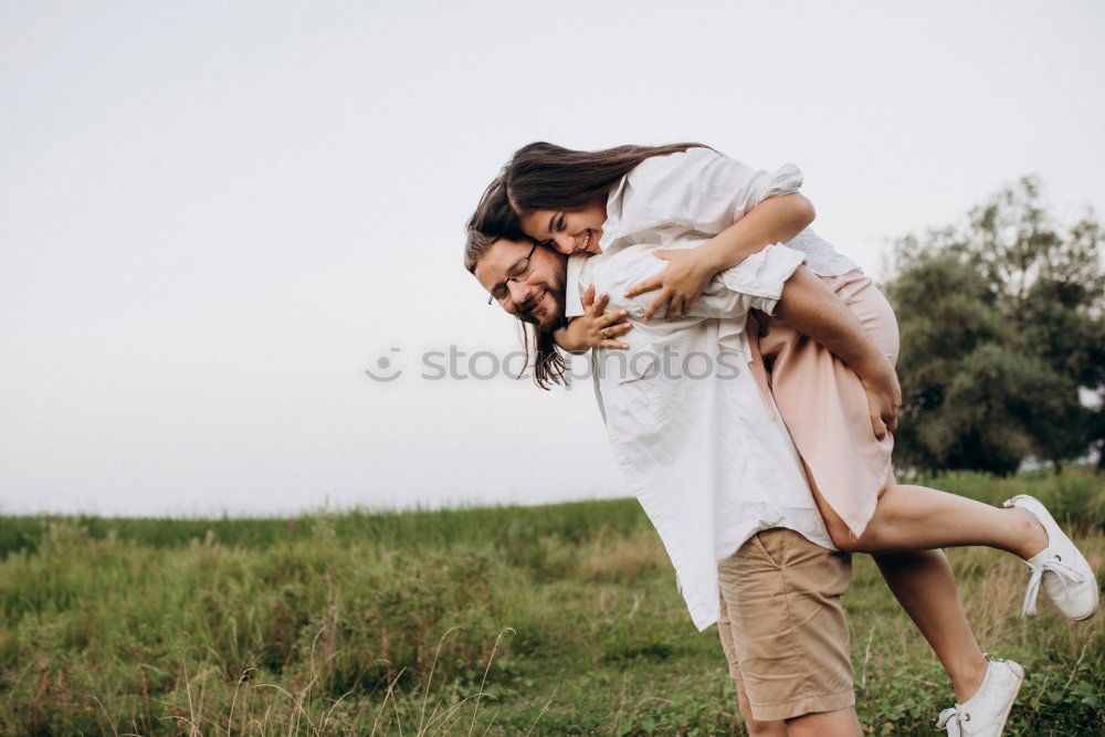 Similar – Image, Stock Photo Blonde woman and bearded man embracing and smiling together with a van in the background at sunset.