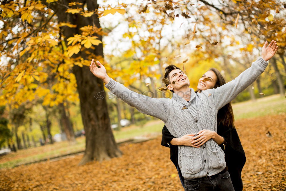 Similar – Couple makes a leaf fight in autumn