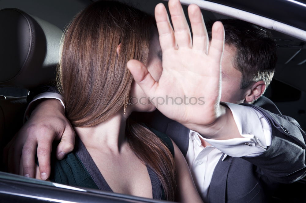 Young couple kissing through of glass car