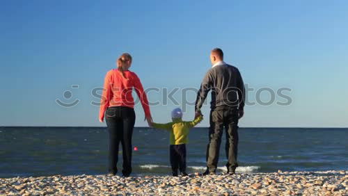 Similar – Rear view of a female senior citizen and two seniors sitting on gravel and looking out to sea