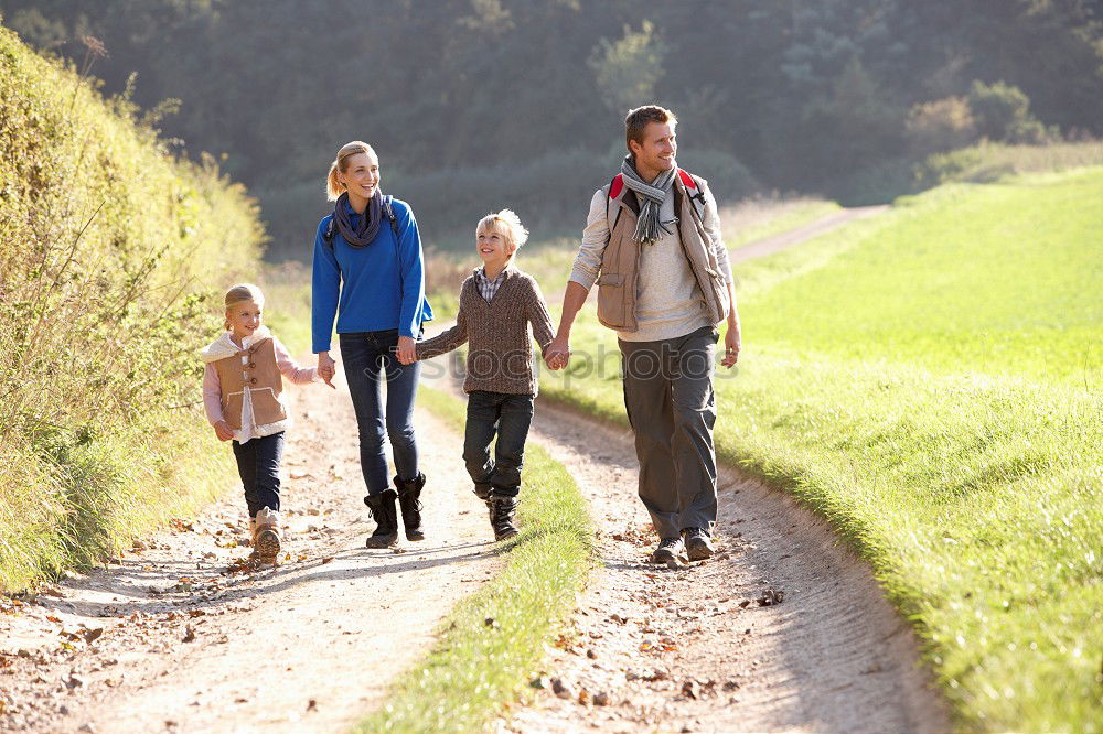 Similar – Grandparents and grandchild jumping on nature path