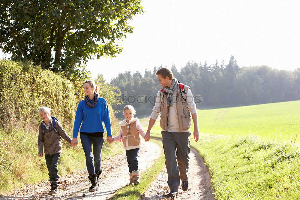 Grandparents and grandchild jumping on nature path