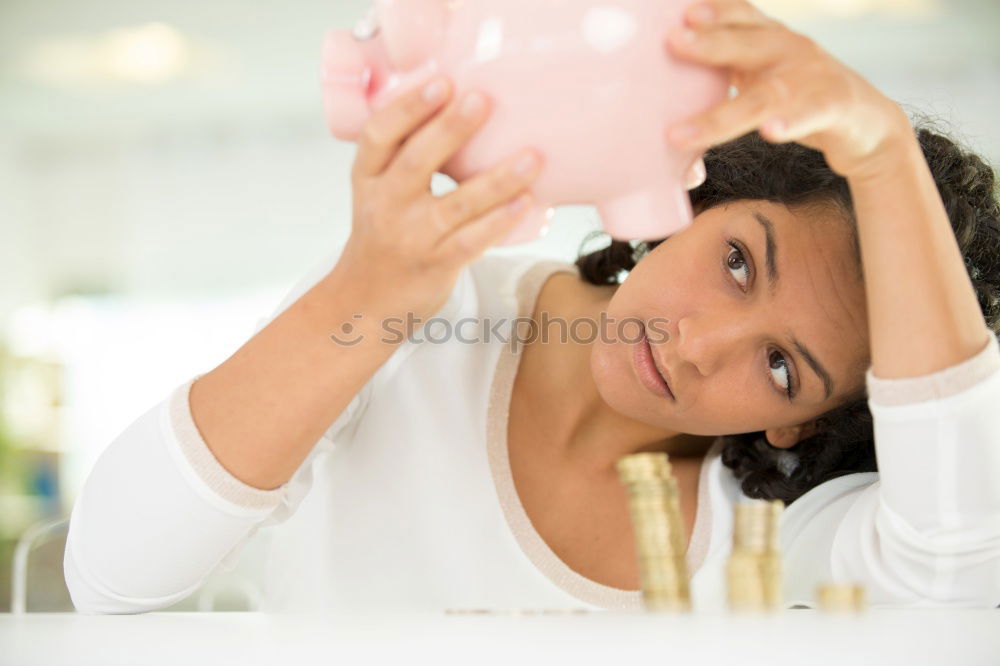 Similar – Thoughtful confused black woman with piggy bank