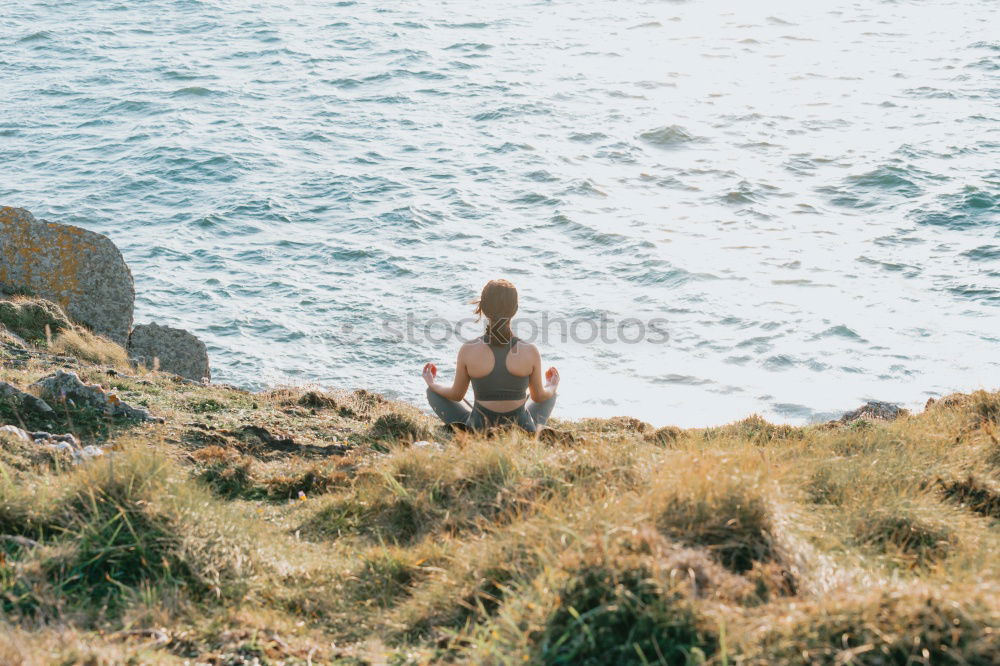 Similar – Girl with arms raised standing on the cliff