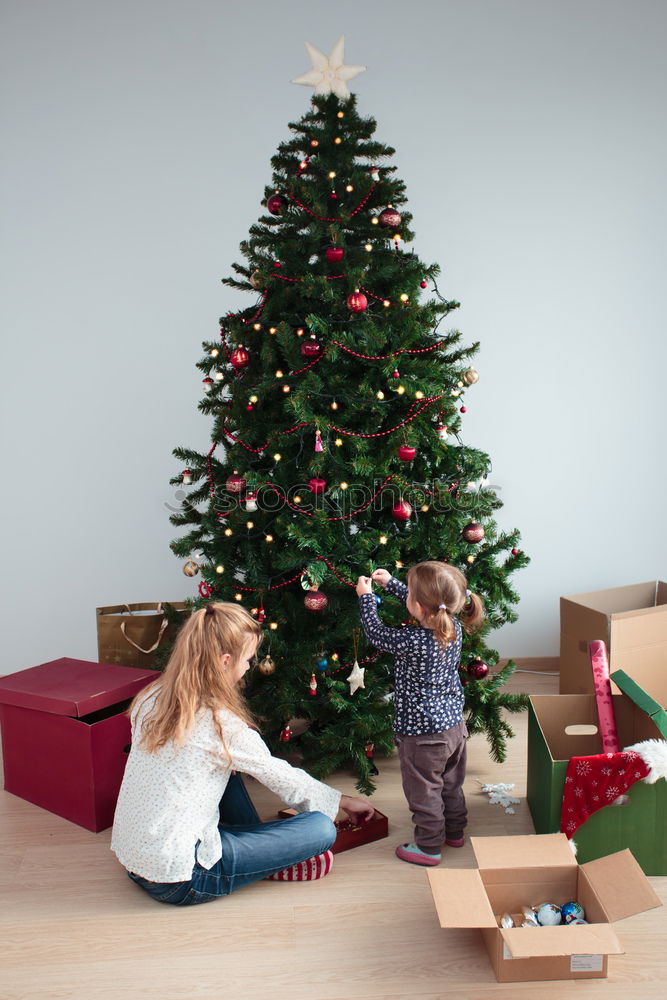 Similar – Young girl and her little sister decorating Christmas tree