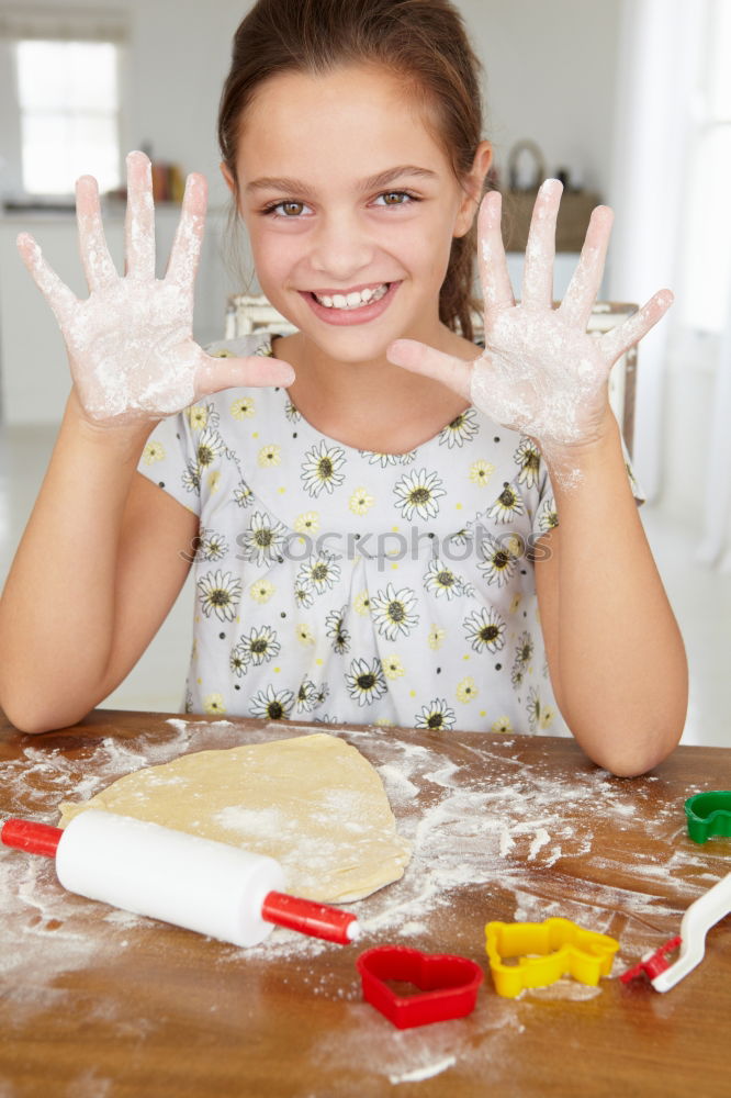 Girl decorating Christmas gingerbread cookies with chocolate